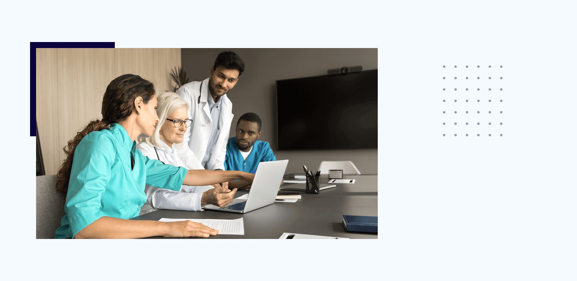 Doctors collaborating around a laptop in meeting.