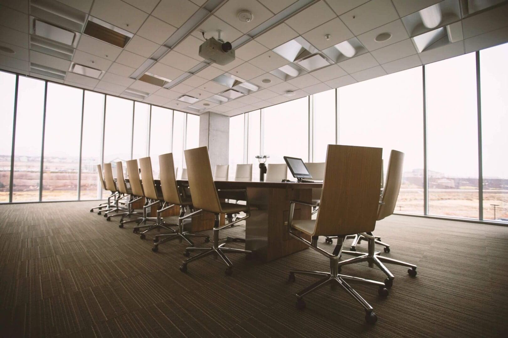 Modern conference room with leather chairs and large windows.